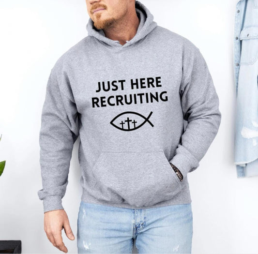 Light gray hoodie sweatshirt that say, "Just here recruiting" with the ichthus fish symbol with three crosses inside the fish.