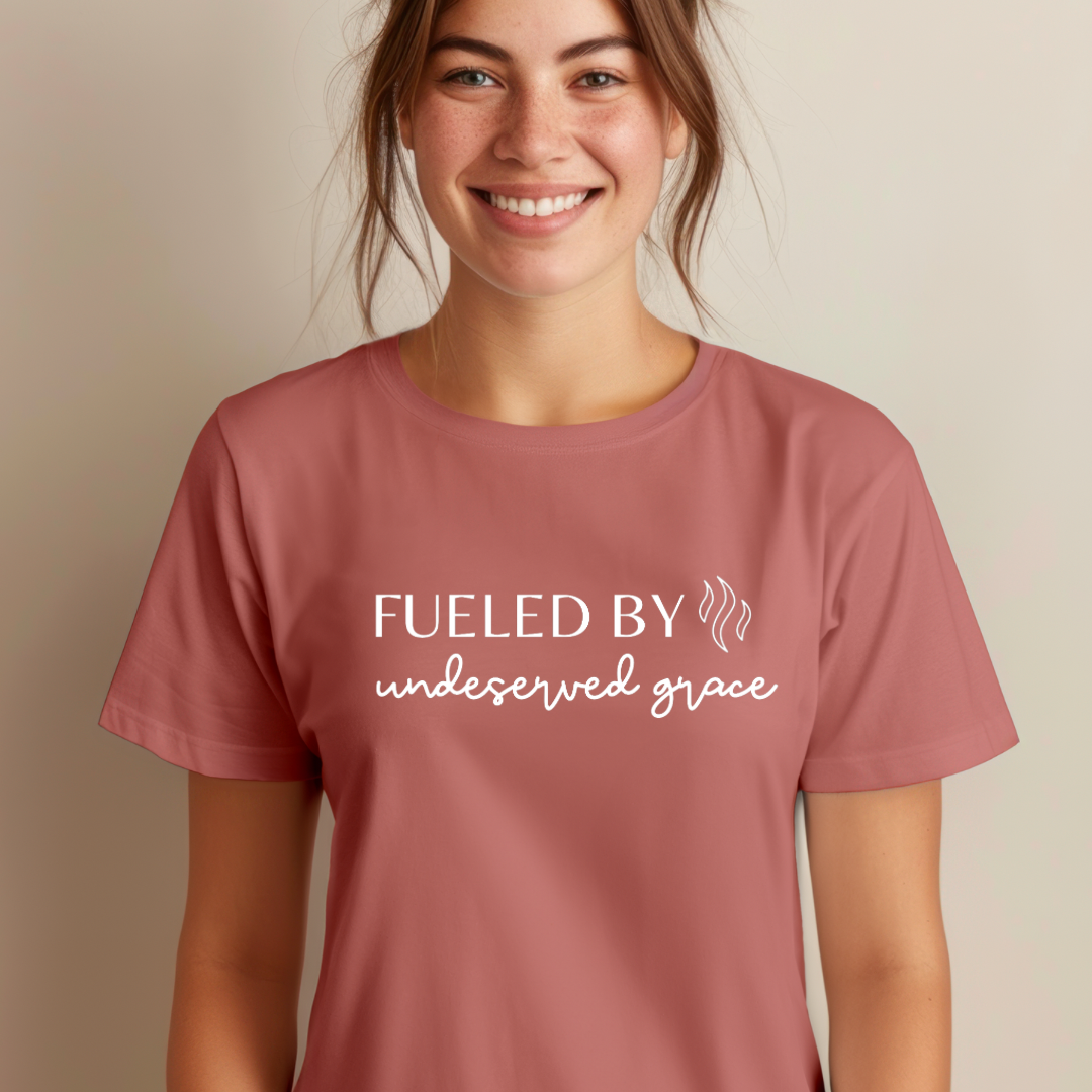 Mauve crewneck t-shirt that says, “Fueled by undeserved Grace”.