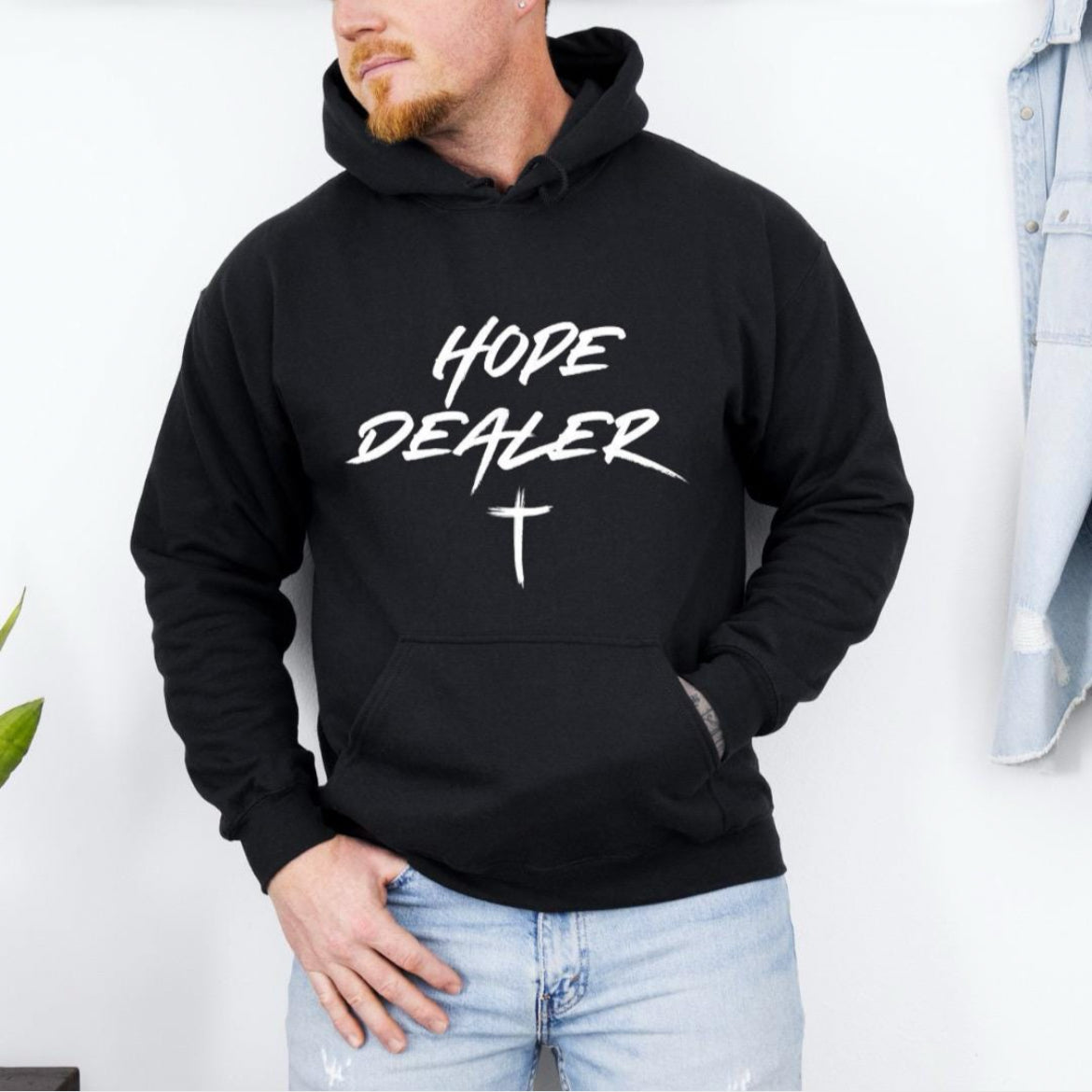 Black hooded sweatshirt that says, "Hope dealer" in graffiti style writing with an image of a cross.