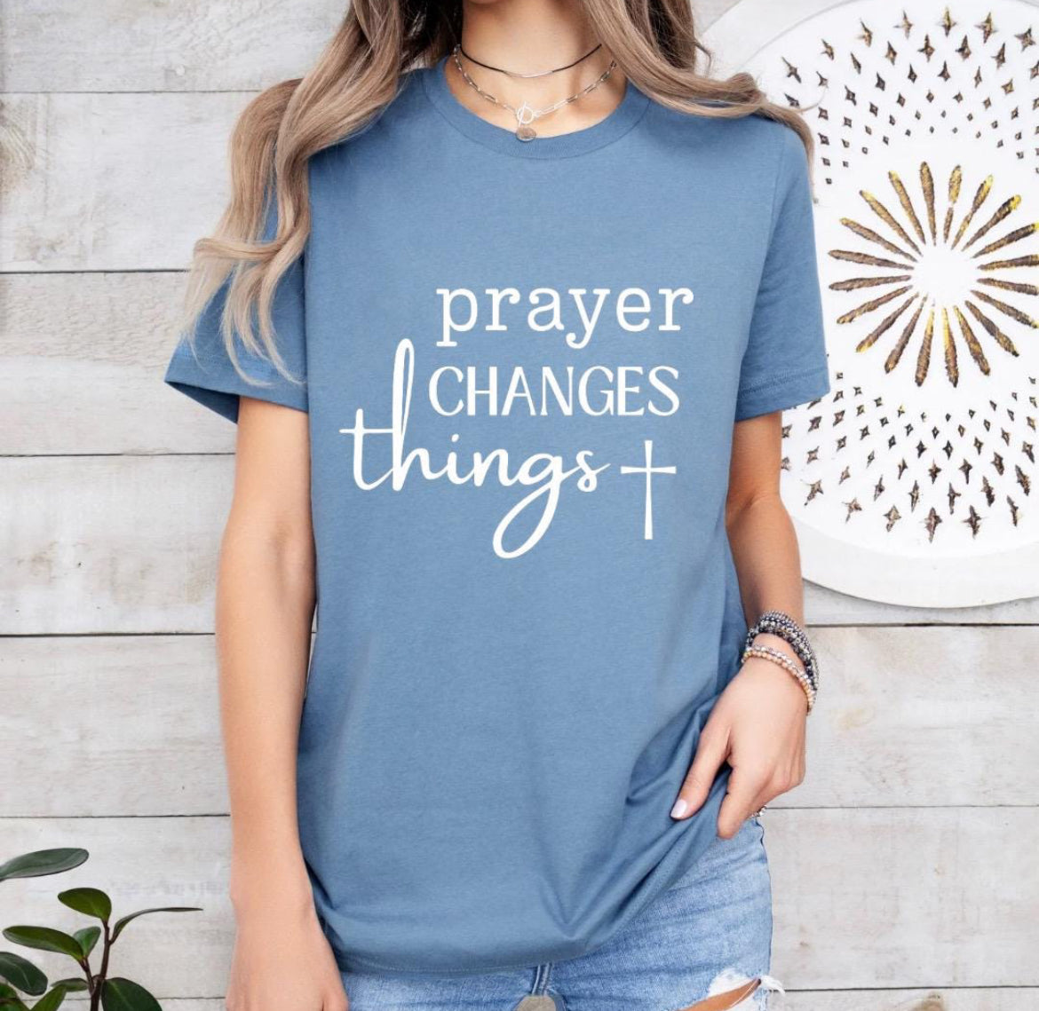 Steel blue crewneck t-shirt that says, “prayer changes things.”