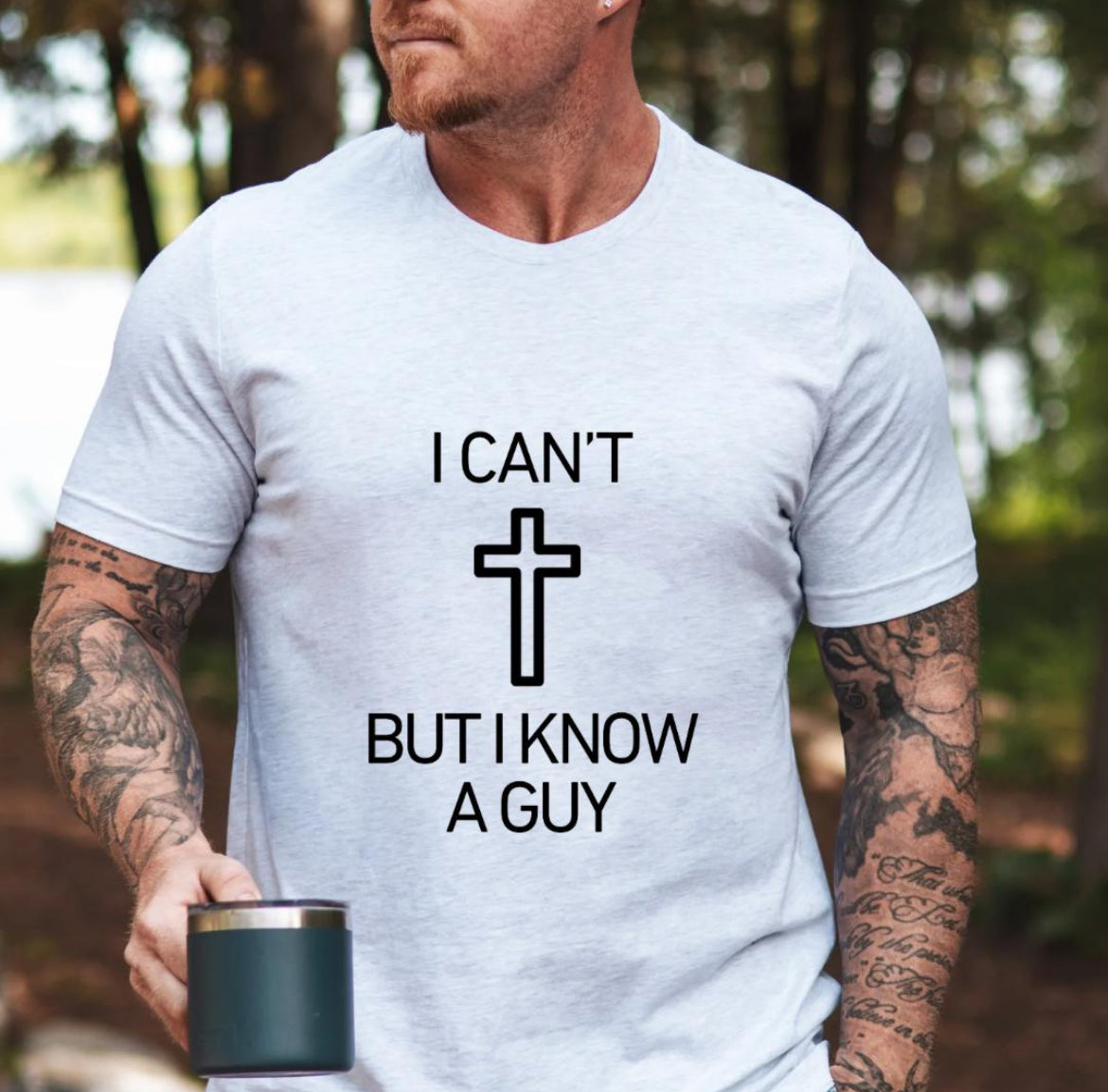 Ash white crewneck t-shirt that says, “I can’t but I know a guy” with a cross in the middle.