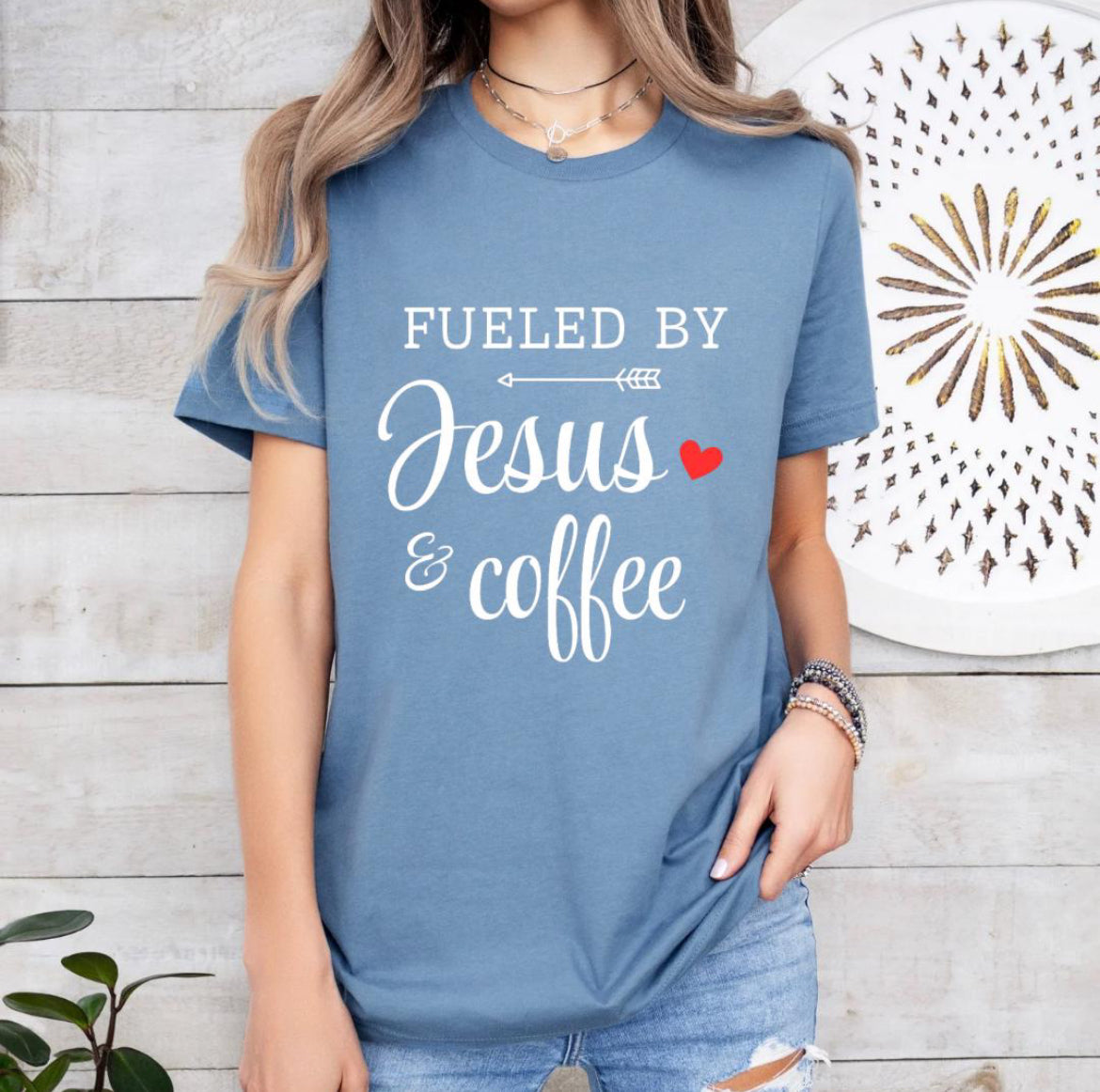 Steel blue crewneck t-shirt that says, “fueled by Jesus and coffee.”