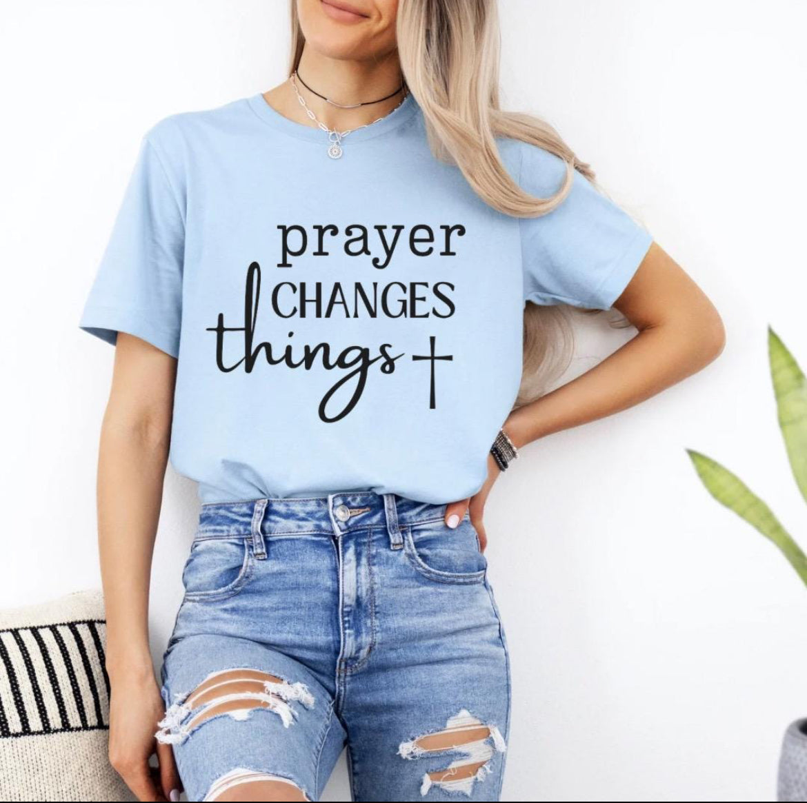 Baby blue crewneck t-shirt that says, “prayer changes things.”