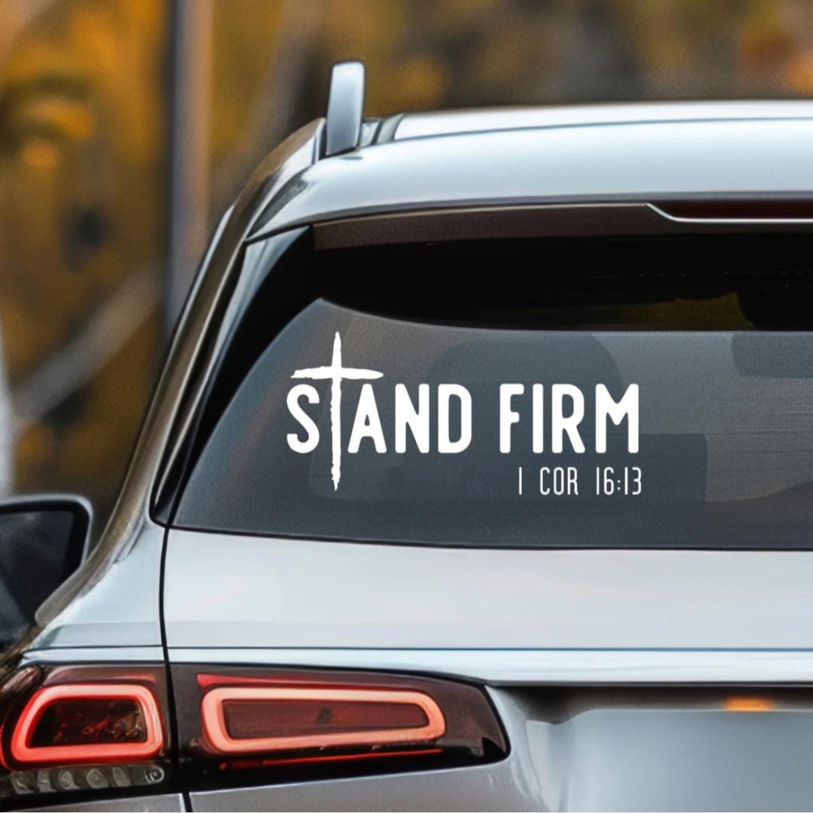 Car decal sticker that says, “Stand firm” in large letters. The “T” in “stand” is a cross. Underneath in smaller letters it says, “1 Corinthians 16 13.”