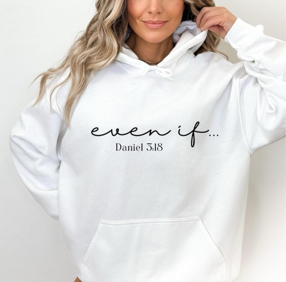 White hooded sweatshirt that says, "Even if" in large cursive letters. Underneath it says, "Daniel 3:18." 