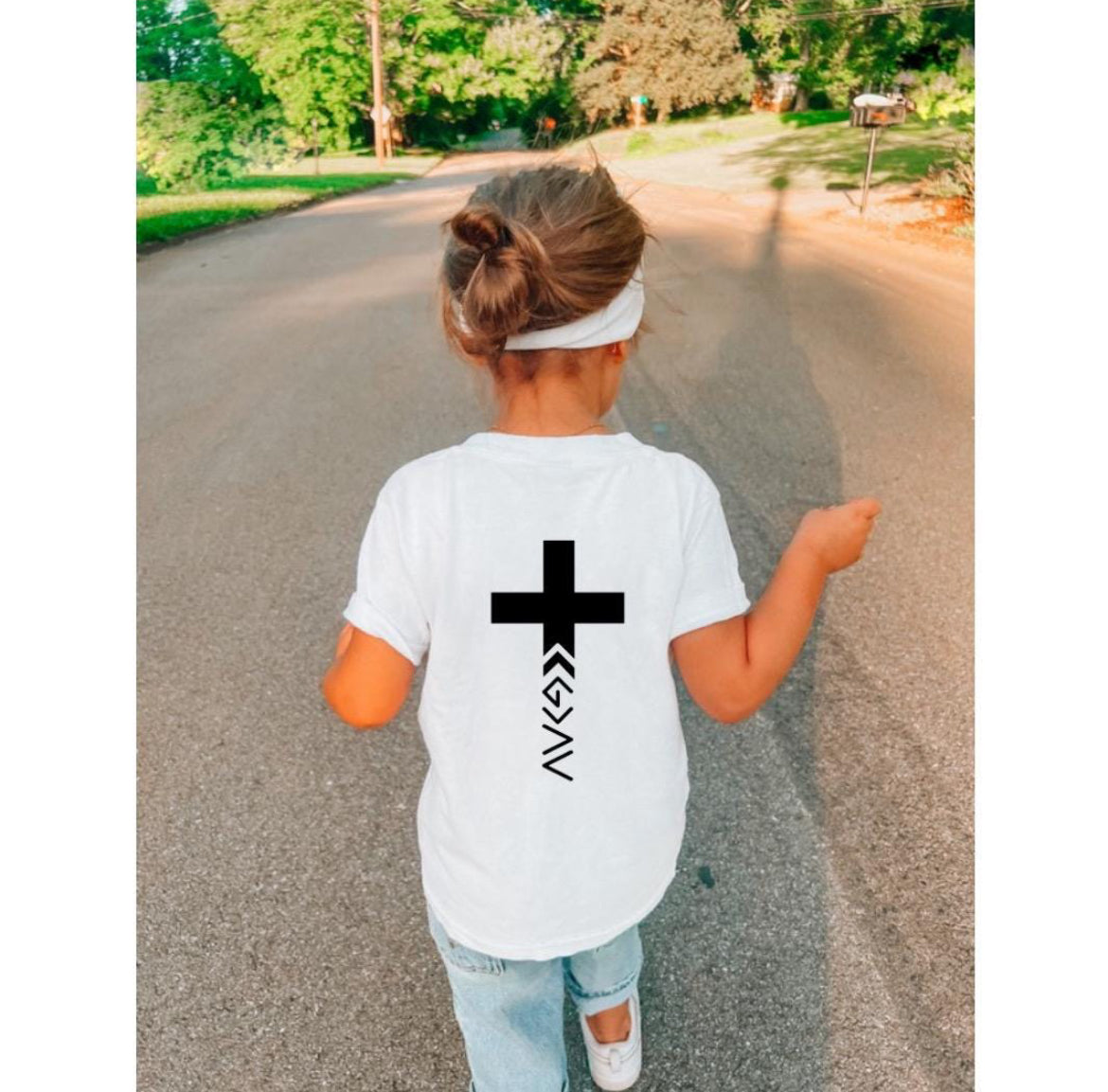 Back of white crewneck t-shirt crewneck t-shirt with a cross on the back that has the symbol “God is greater than the highs and lows” as the bottom part of the cross. 