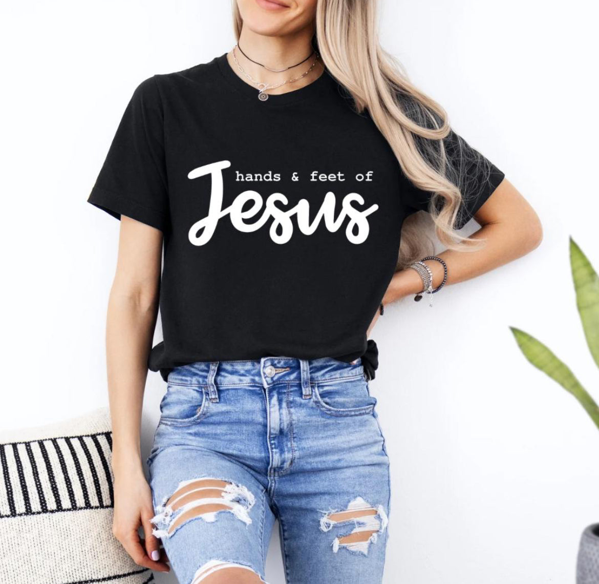 Black crewneck t-shirt that says, “hands and feet of Jesus.”