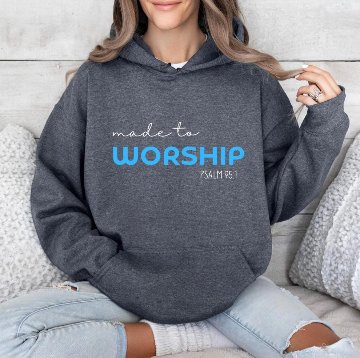 Dark grey hoodie that says, "Made to worship" where the word "worship" Is a bright blue. Underneath in smaller letters it says, "Psalm 95 1."