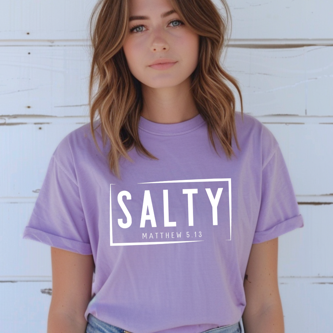 Lavender crewneck t-shirt that says, “SALTY” in large capital letters. Underneath in smaller letters it says, “Matthew 5:13.” Christian Apparel