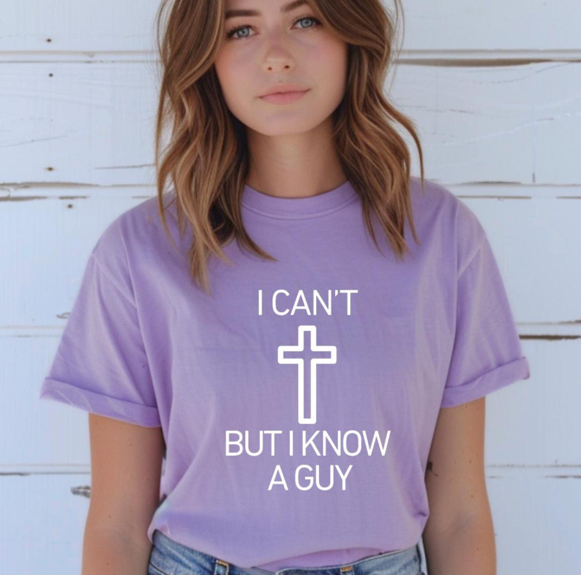 Lavender crewneck t-shirt that says, “I can’t but I know a guy” with a cross in the middle.