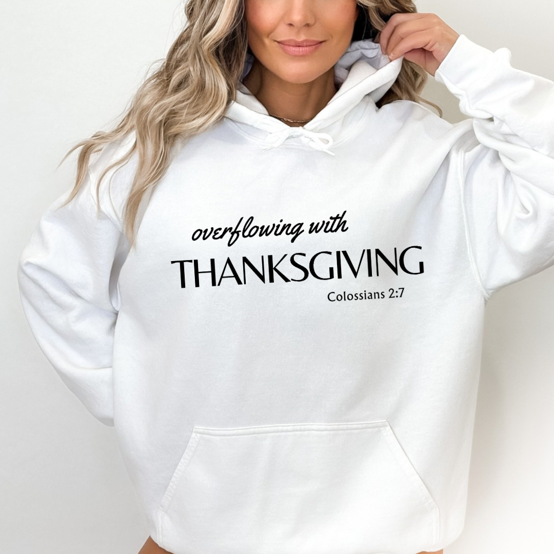 White hoodie sweatshirt that says, “overflowing with Thanksgiving. Colossians 2:7.”