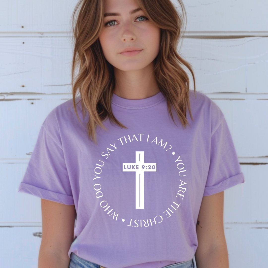 Lavender crewneck t-shirt that says, “who do you say that I am? you are the Christ?” With a cross that says, “Luke 9:29” through the middle. 