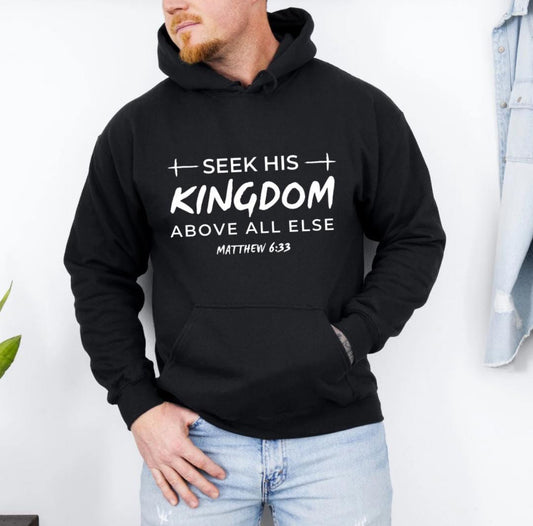 Black hoodie that says, "Seek his Kingdom above all else." Underneath in smaller letters it says, "Matthew 6 33." There are two crosses as embellishments.