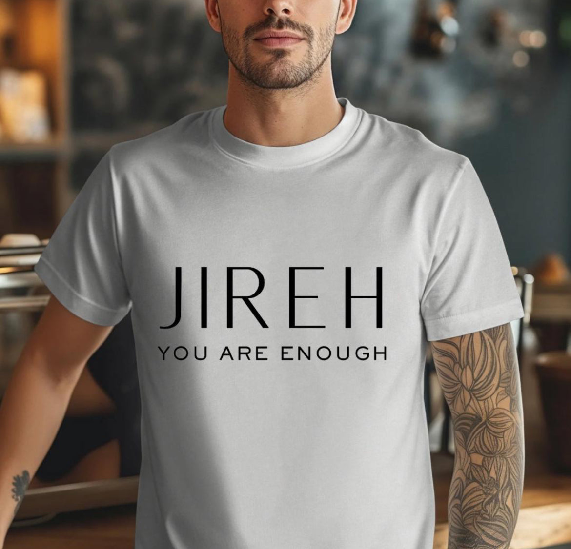 Grey crewneck t-shirt that says, “jireh” in large letters. Underneath it says, “you are enough.”