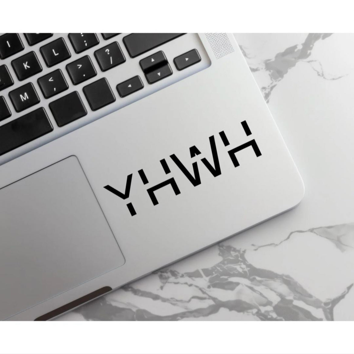 Laptop keyboard sticker decal that says, “YHWH” in large capital letters. 