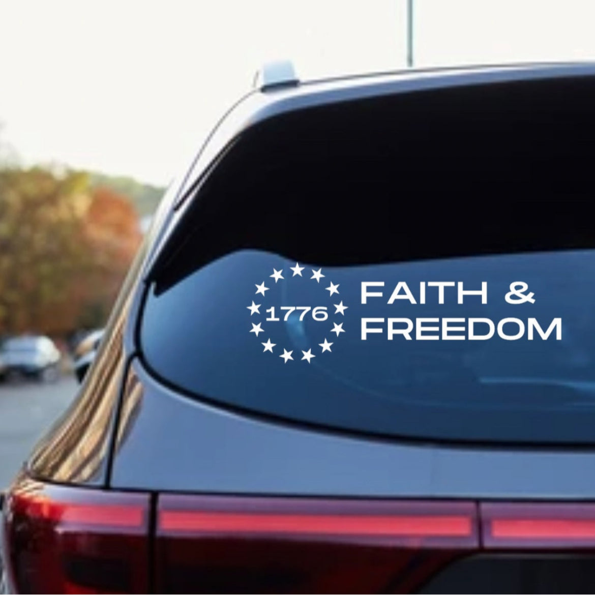 Car decal sticker that says, “Faith and freedom” with the Betsy Ross flag stars symbol. In the middle of the stars it says, “1776.”