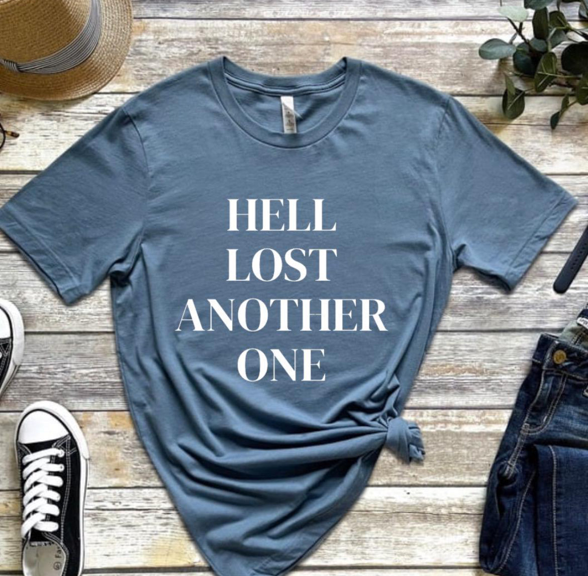 Steel blue crewneck t-shirt that says, “Hell lost another one.”