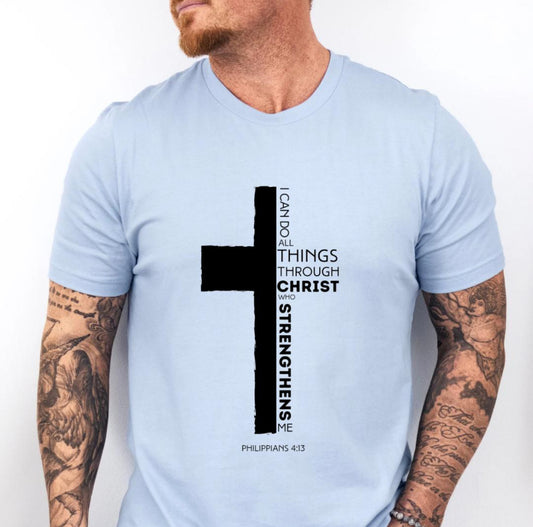 Baby blue crewneck t-shirt with a cross where half of the cross is the Bible verse Philippians 4:13. It says, “I can do all things through Christ who strengthens me.”