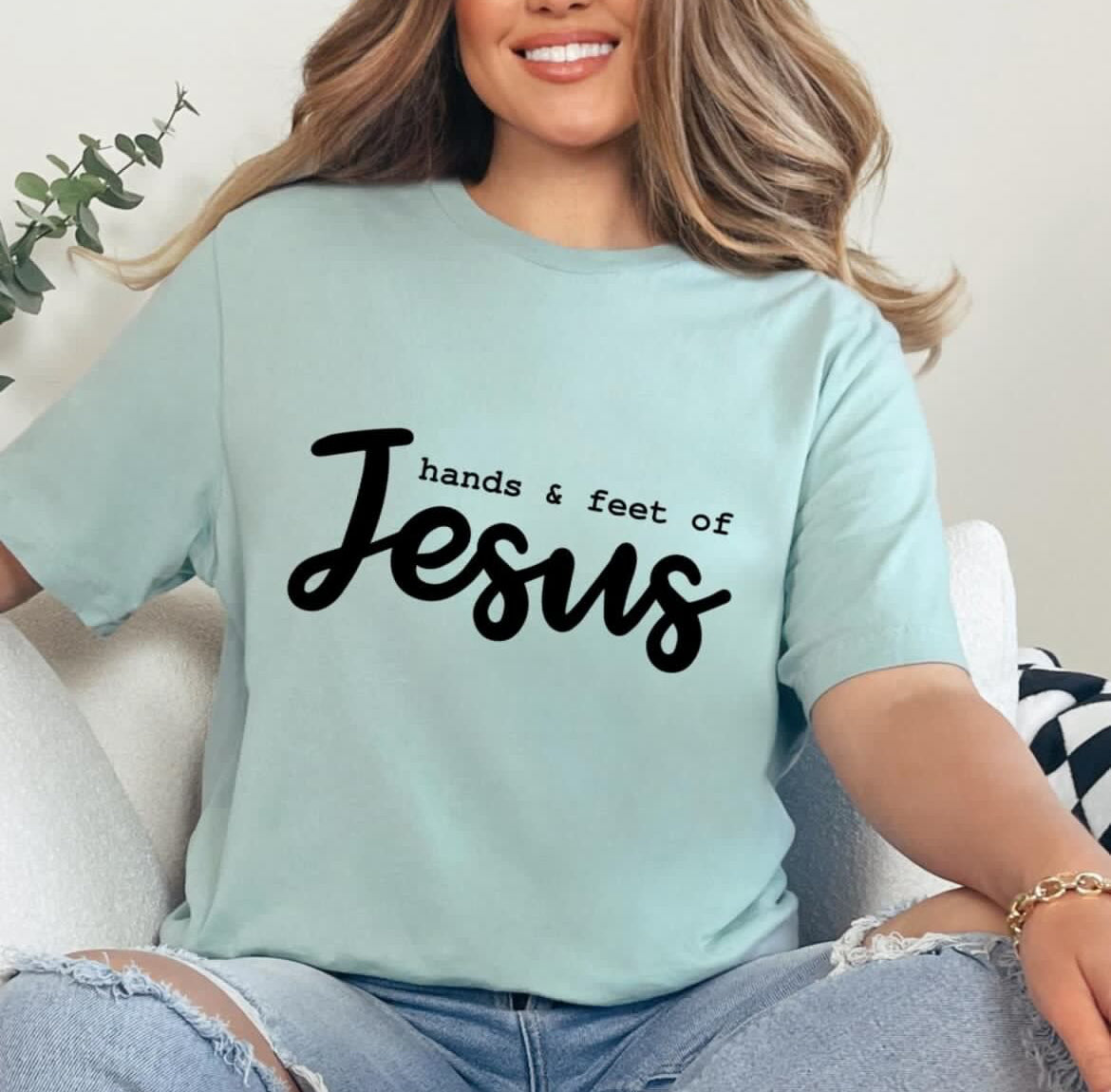 Dusty green crewneck t-shirt that says, “hands and feet of Jesus.”