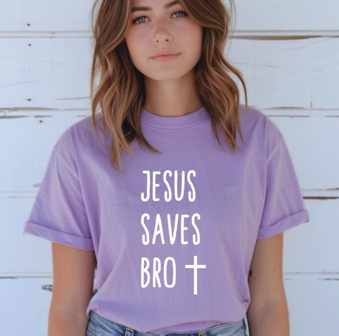 Lavender crewneck t-shirt that says, “Jesus saves bro” with a cross. 