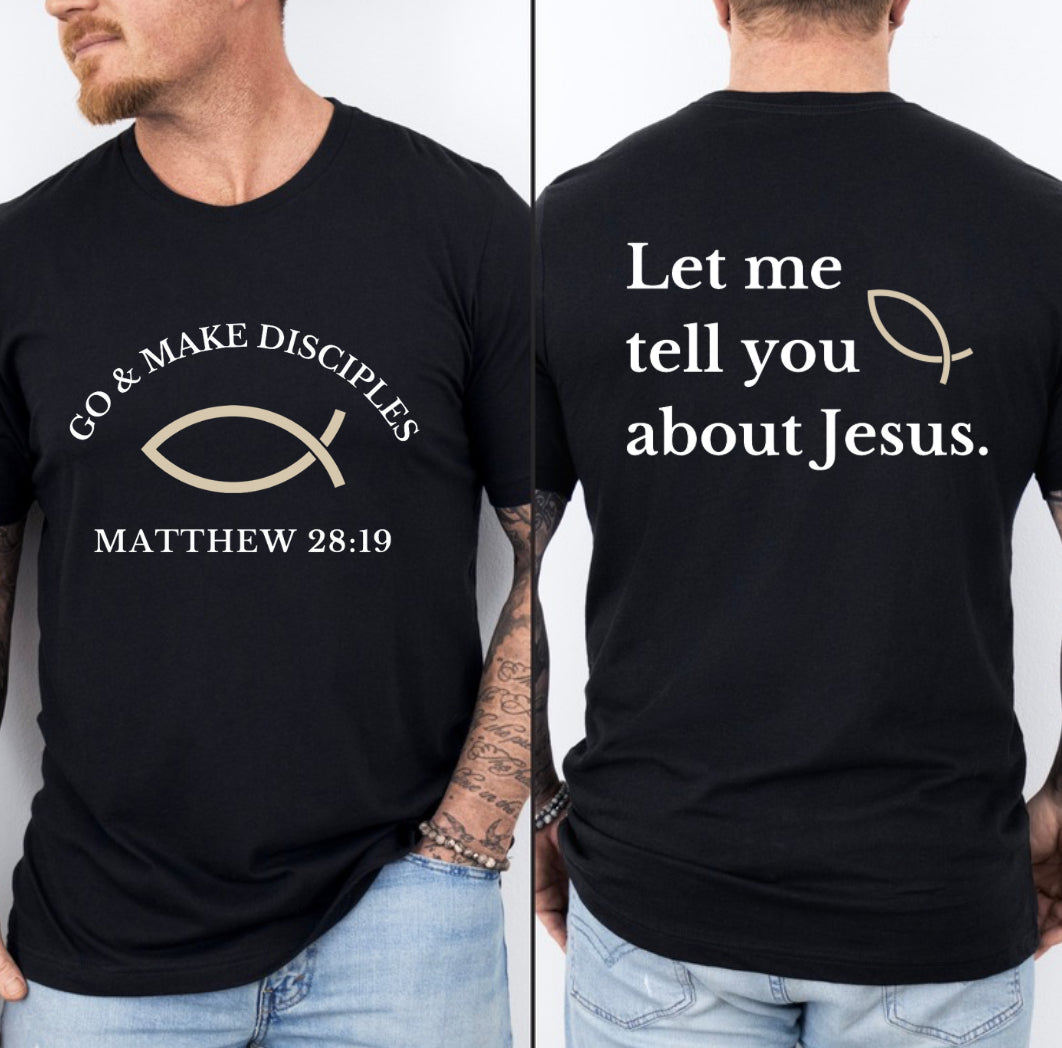 Black crewneck t shirt that says, "Go and make disciples, Matthew 28 19 on the front." On the back it says, "Let me tell you about Jesus." There is an ichthus Jesus fish symbol on the front and back. 