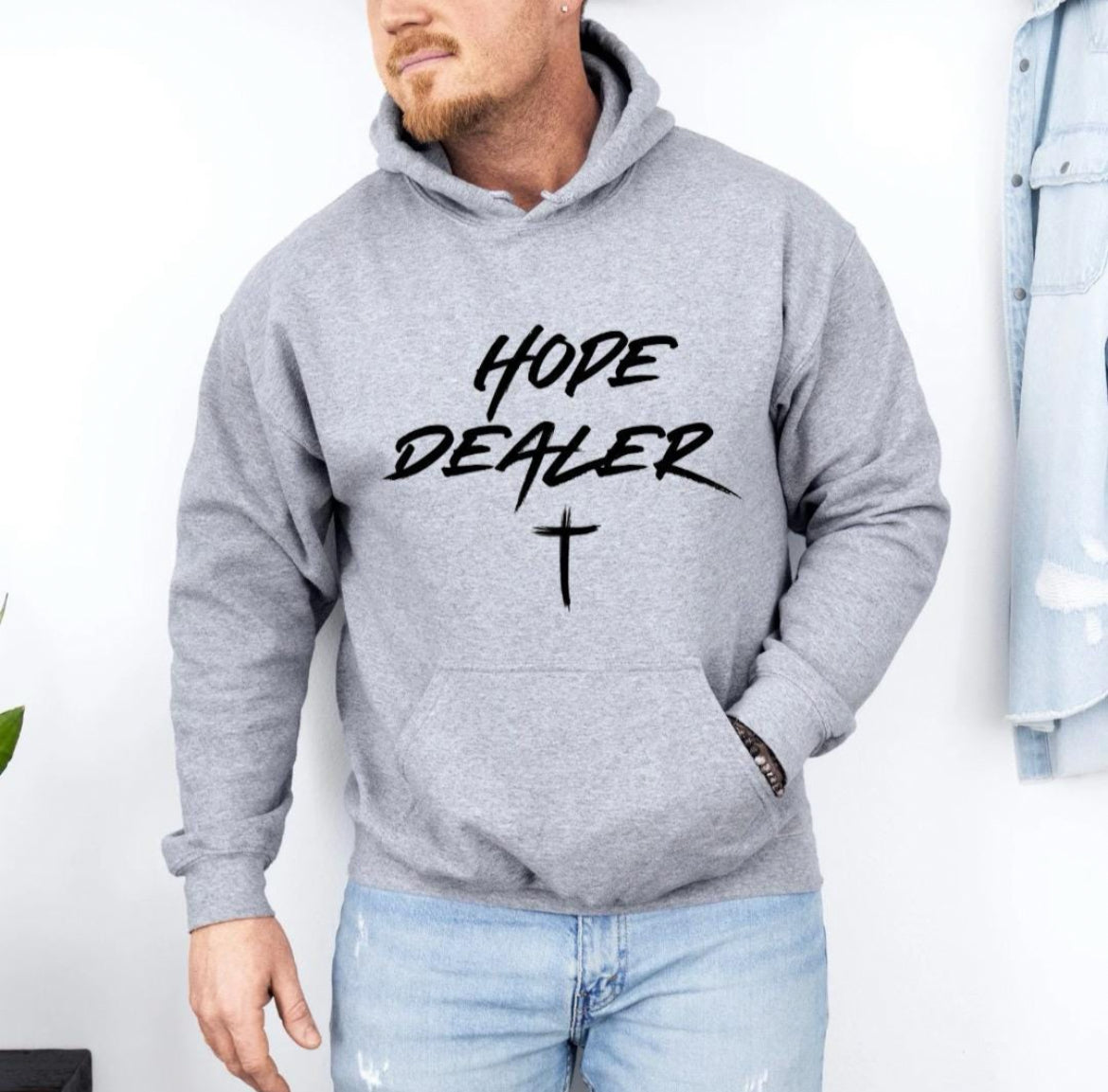 Light sporty gray hooded sweatshirt that says, "Hope dealer" in graffiti style writing with an image of a cross.