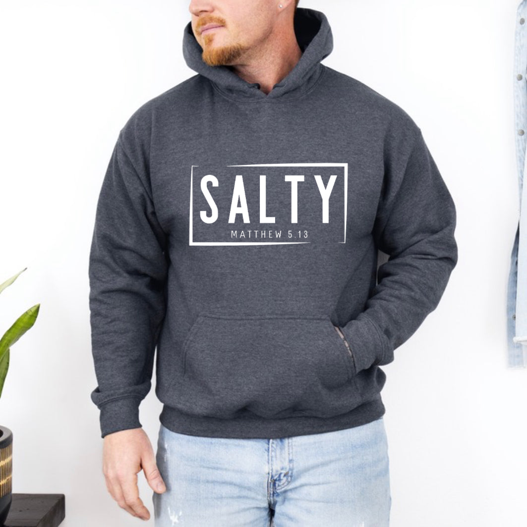 Dark grey heather hoodie sweatshirt that says, “SALTY” in large capital letters. Underneath in smaller letters it says, “Matthew 5:13.”