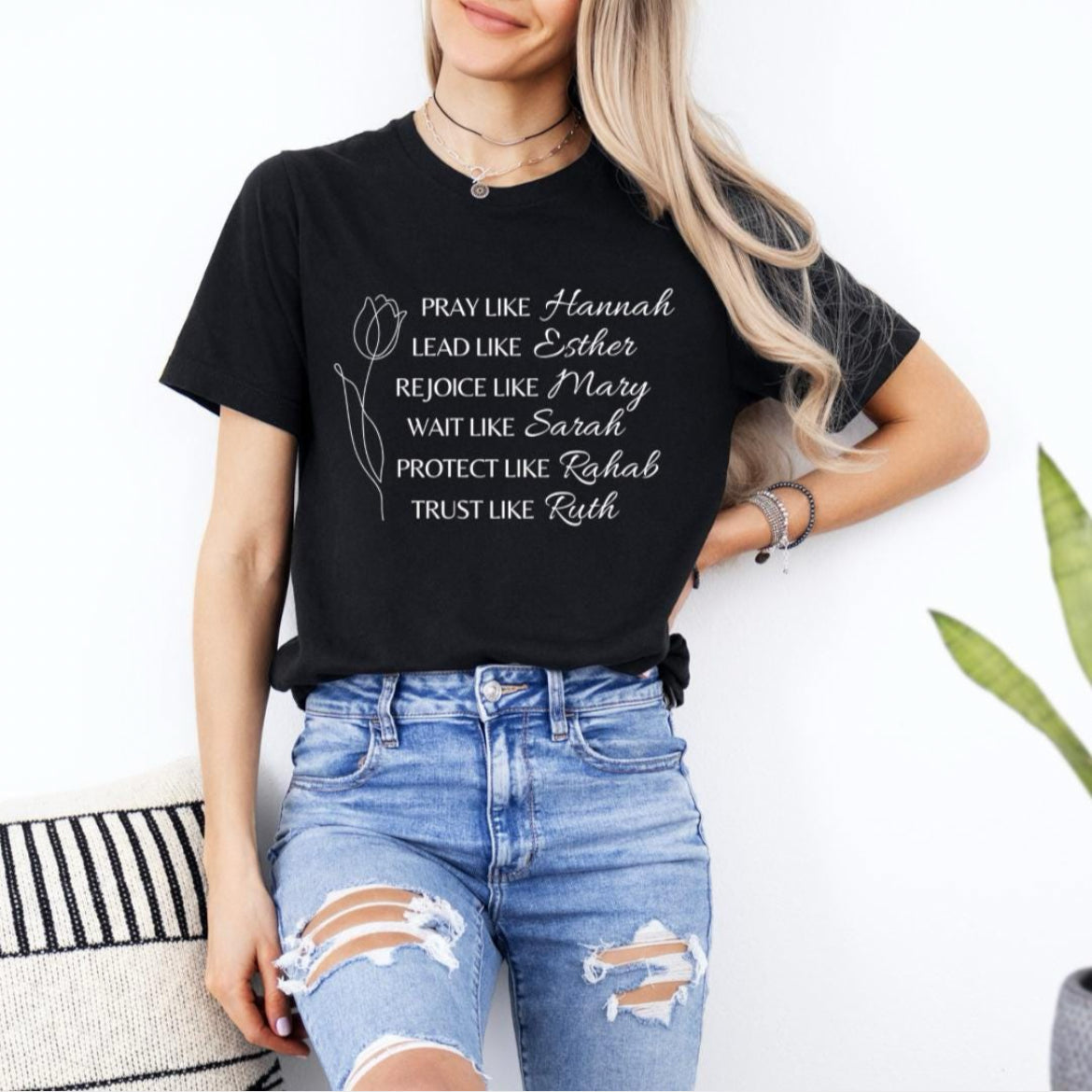 Black crewneck t-shirt that says, “Pray like Hannah, lead like Esther, rejoice like Mary, wait like Sarah, protect like Rahab, trust like Ruth.”