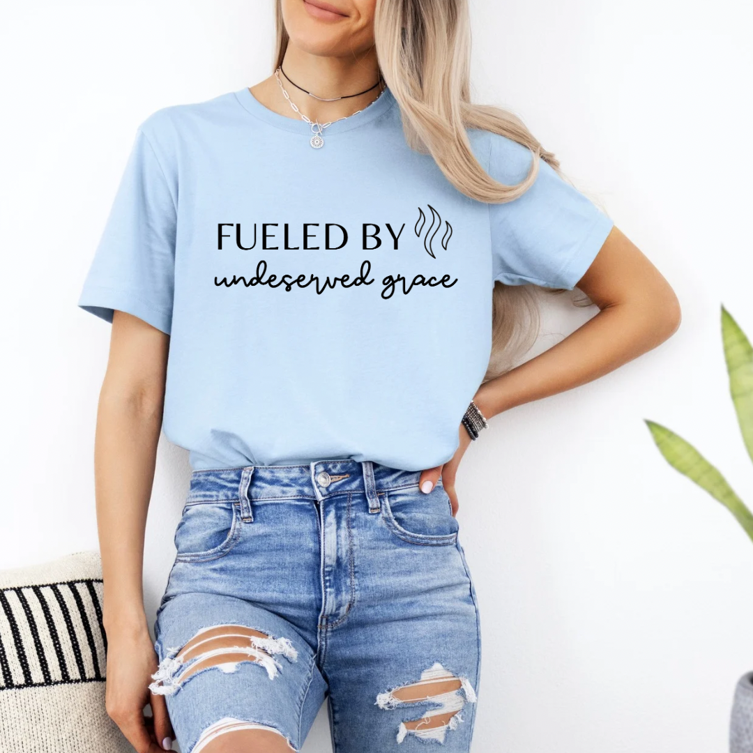 Baby blue crewneck t-shirt that says, “Fueled by undeserved Grace”.