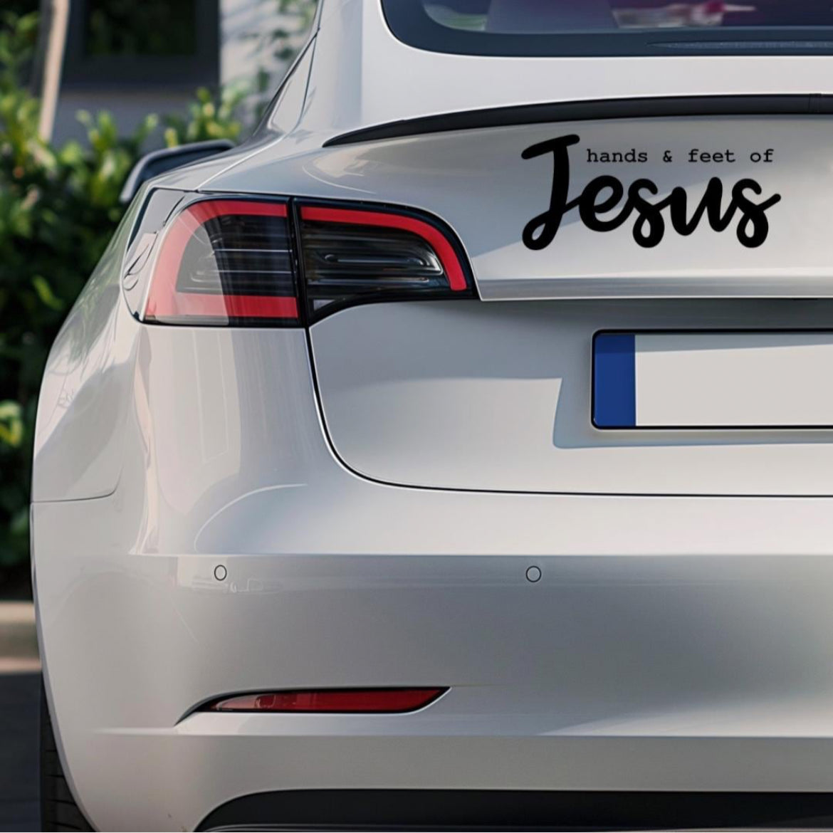 Bumper sticker decal that says, “hands and feet of Jesus”. The word “Jesus” is in large cursive letters. 