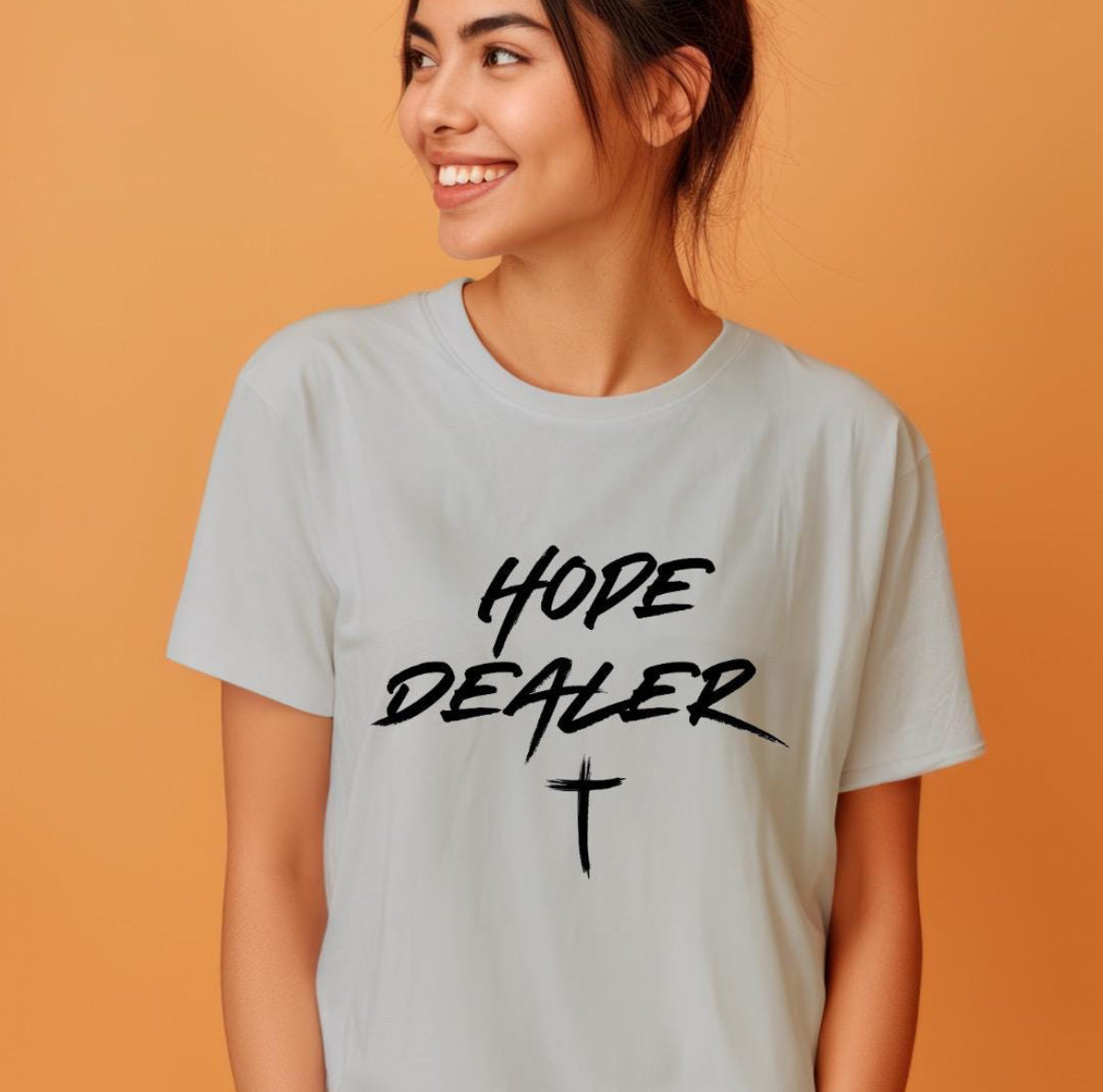 Grey crewneck t-shirt that says, “Hope dealer” in an urban graffiti style writing with a cross. 