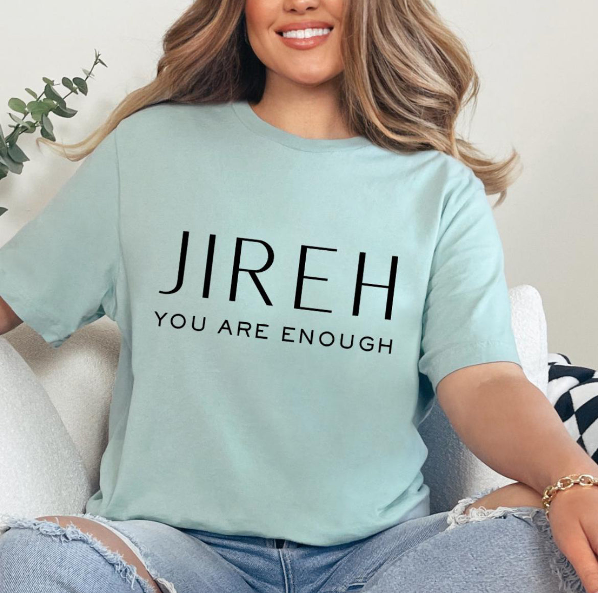 Dusty green crewneck t-shirt that says, “jireh” in large letters. Underneath it says, “you are enough.”