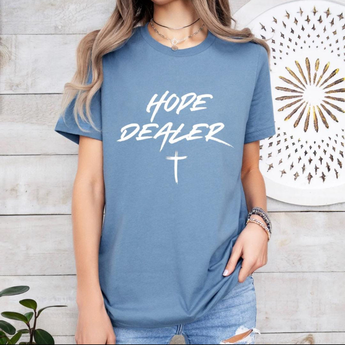 Steel blue crewneck t-shirt that says, “Hope dealer” in an urban graffiti style writing with a cross. 