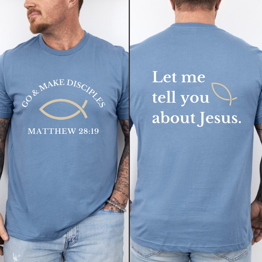 Steel blue crewneck t shirt that says, "Go and make disciples, Matthew 28 19 on the front." On the back it says, "Let me tell you about Jesus." There is an ichthus Jesus fish symbol on the front and back. 