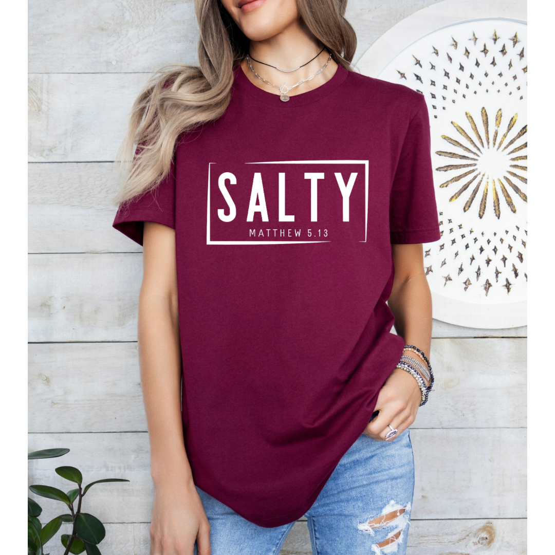 Maroon crewneck t-shirt that says, “SALTY” in large capital letters. Underneath in smaller letters it says, “Matthew 5:13.” Christian Apparel