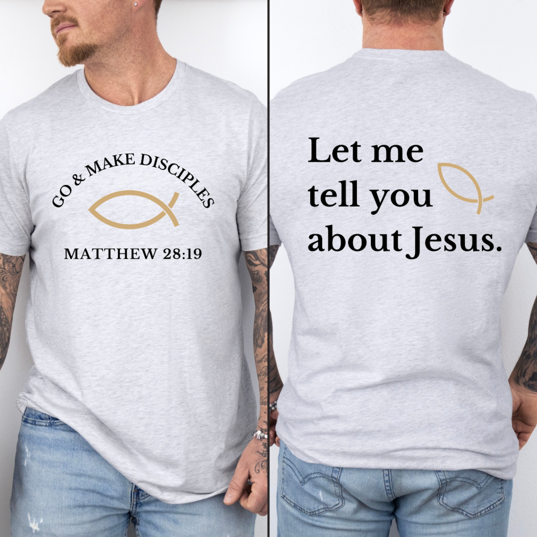 Ash white crewneck t shirt that says, "Go and make disciples, Matthew 28 19 on the front." On the back it says, "Let me tell you about Jesus." There is an ichthus Jesus fish symbol on the front and back. 