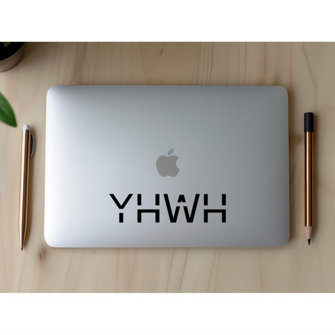 Laptop decal sticker that says, “YHWH” in large capital letters. 