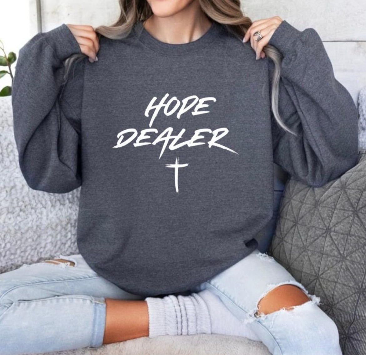 Dark grey heather crewneck sweatshirt that says, “Hope dealer” in graffiti style writing with a cross. 