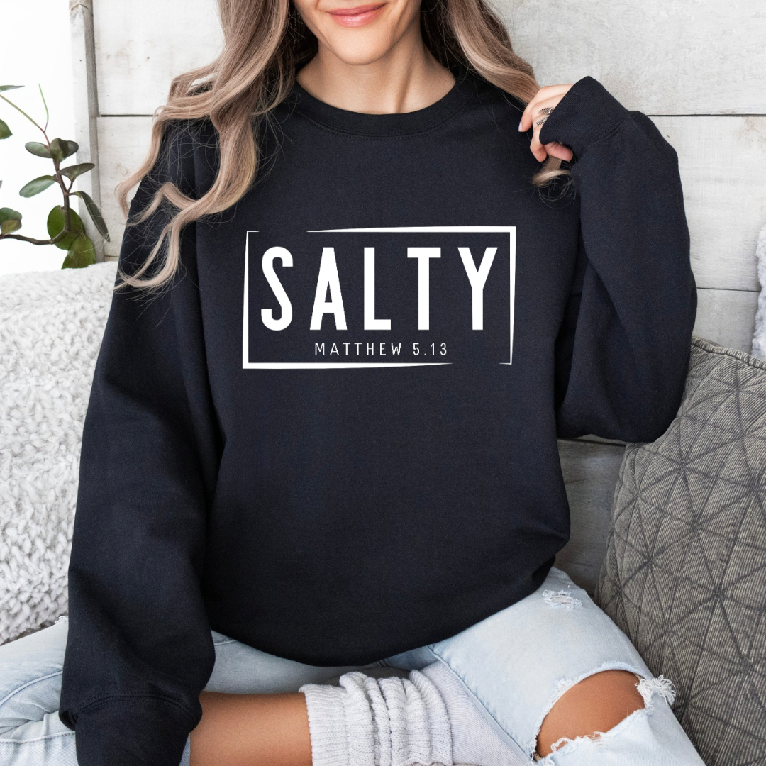 Black crewneck sweatshirt that says, “SALTY” in large capital letters. Underneath in smaller letters it says, “Matthew 5:13.”