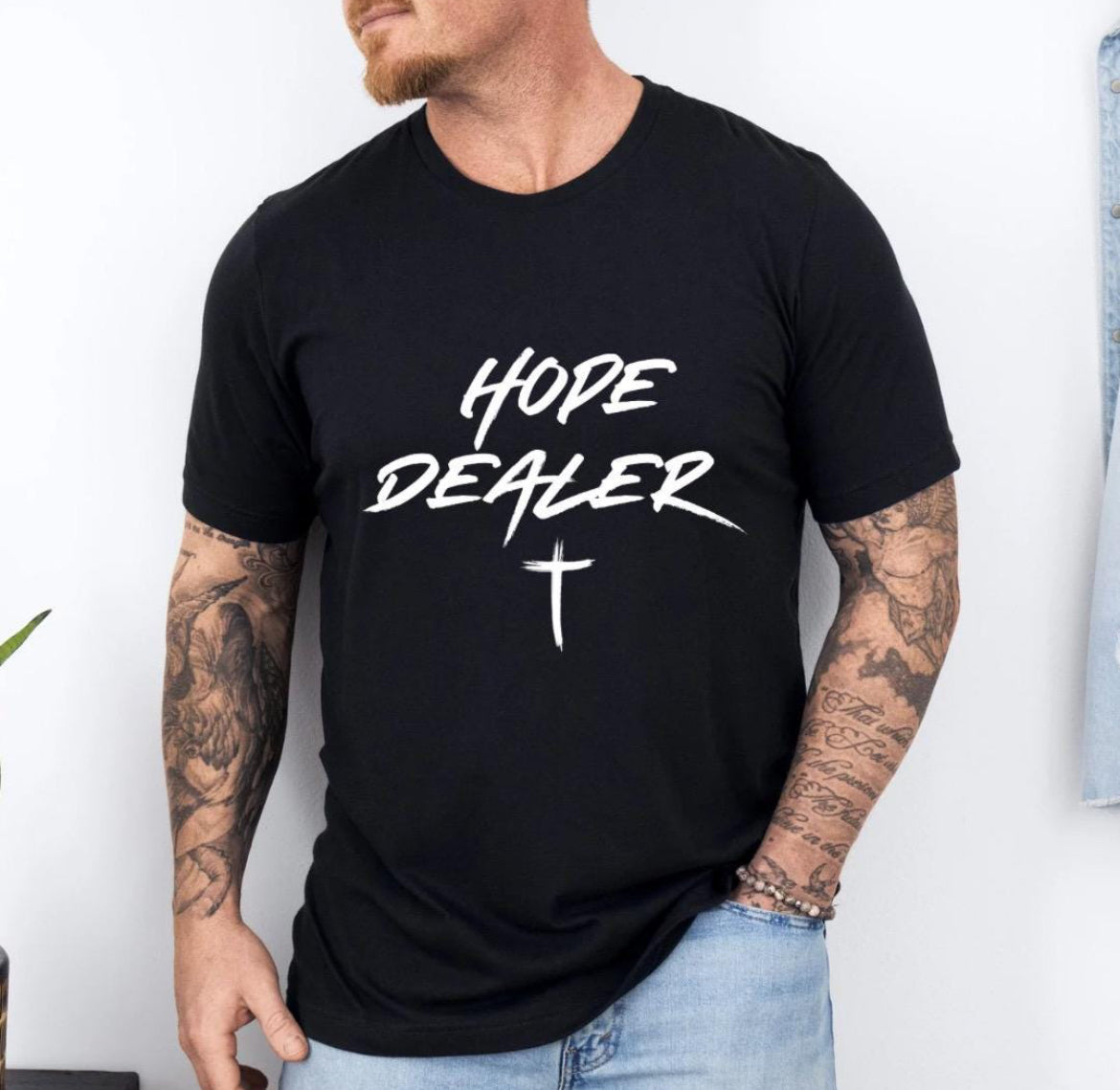 Black crewneck t-shirt that says, “Hope dealer” in an urban graffiti style writing with a cross. 