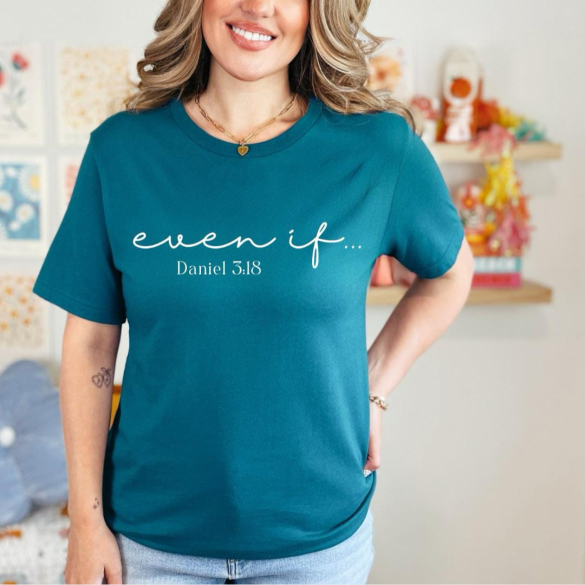 Deep teal crewneck t-shirt that says, “even if…” in cursive letters. Underneath in smaller letters it says, “Daniel 3 18.”