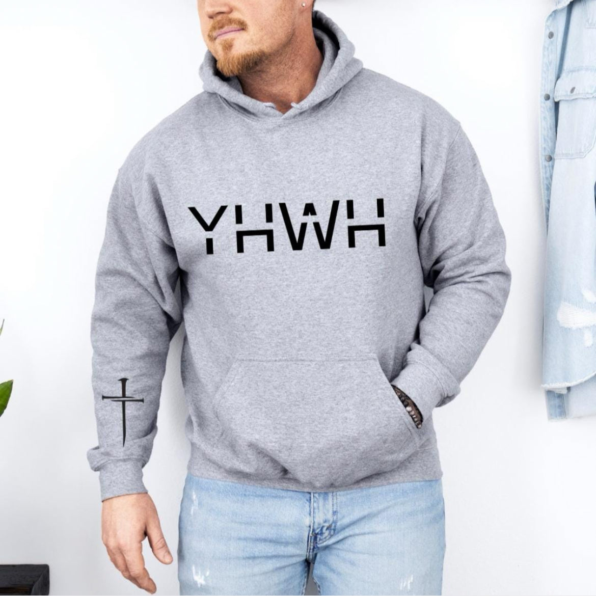 Light gray hoodie that says, that says, "YHWH" with a cross on the sleeve. 