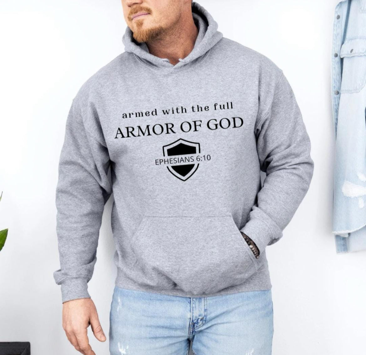 Light gray hoodie that says, "armed with the full armor of God." Underneath is a shield and in the middle of the shield it says, "Ephesians 6 10."