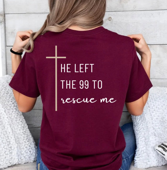 Maroon crewneck T-Shirt that says, "He left the 99 to rescue me" with a large tan cross. On the front it says, "Matthew 18:13 rescued" with a tan sheep. 