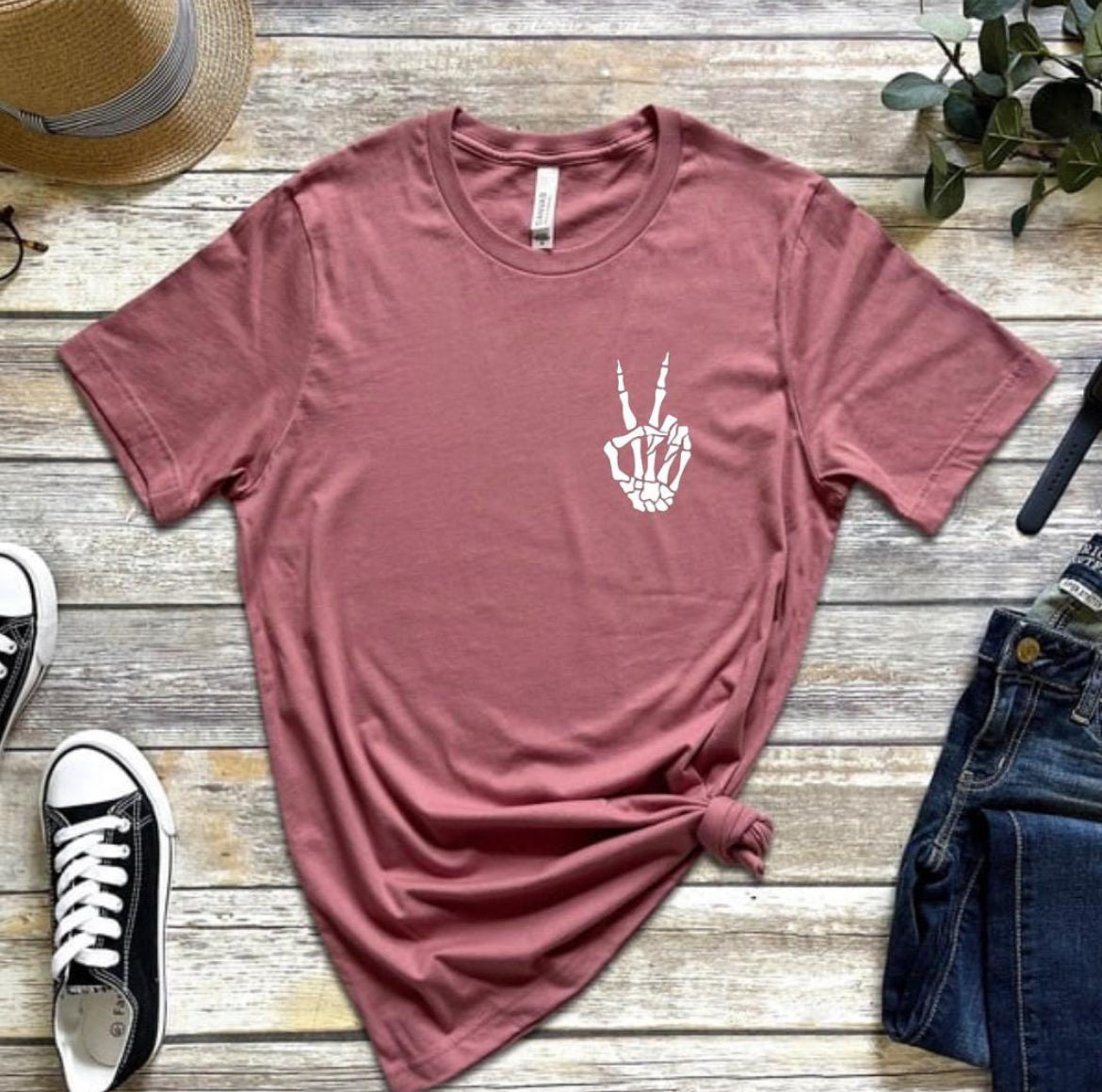 Mauve crewneck t-shirt that has a small bones hand peace sign in the upper left-hand corner. 