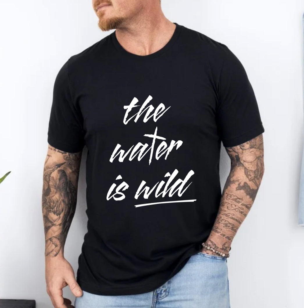 Black crewneck t-Shirt that says, “the water is wild”. The “t” in water is a cross. The back says, “I hear the voice of my father say this is my child” with a large cross in the middle.