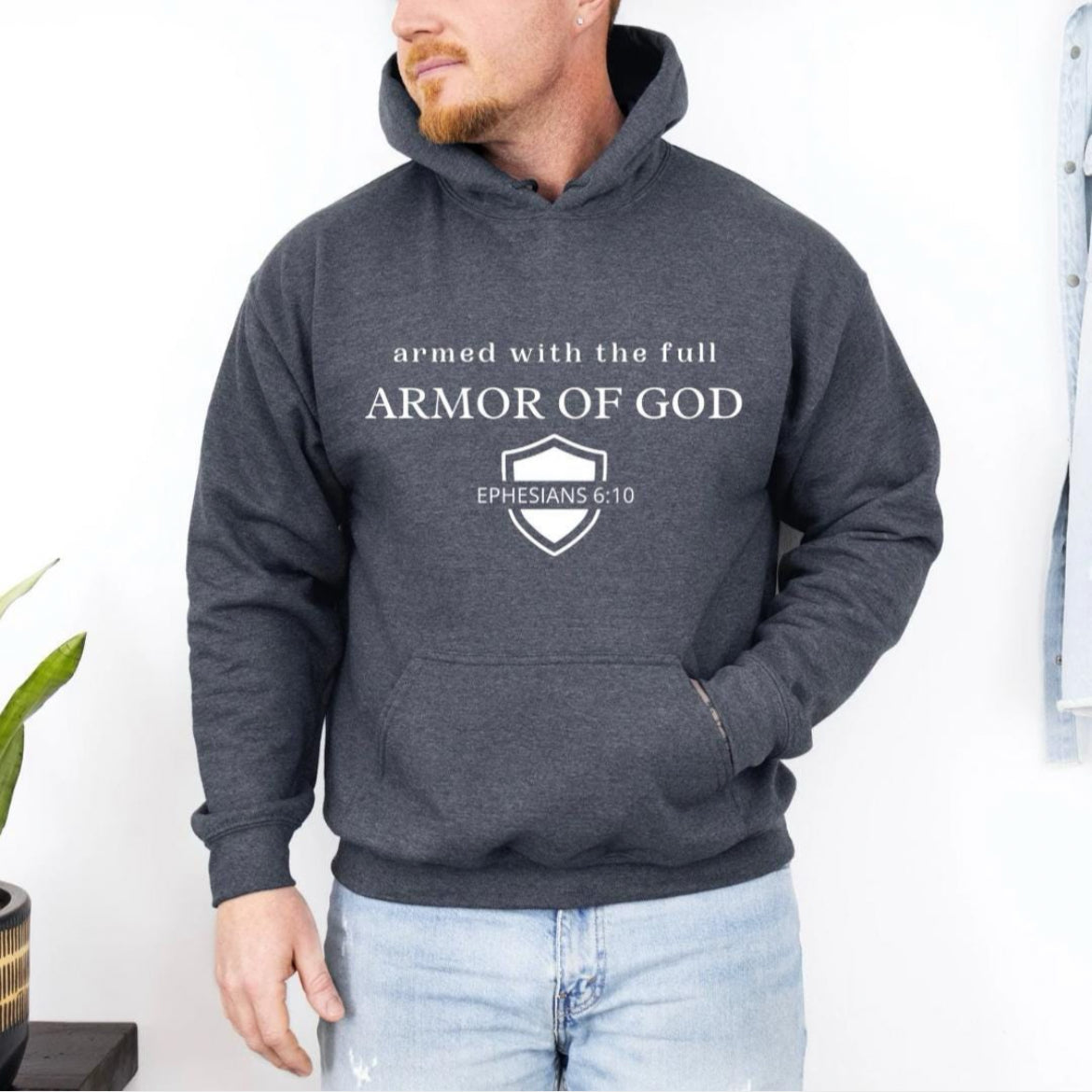 Dark gray hoodie that says, "armed with the full armor of God." Underneath is a shield and in the middle of the shield it says, "Ephesians 6 10."