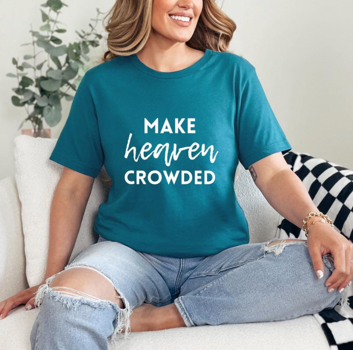 Deep teal crewneck t-shirt that says, “make heaven crowded.”