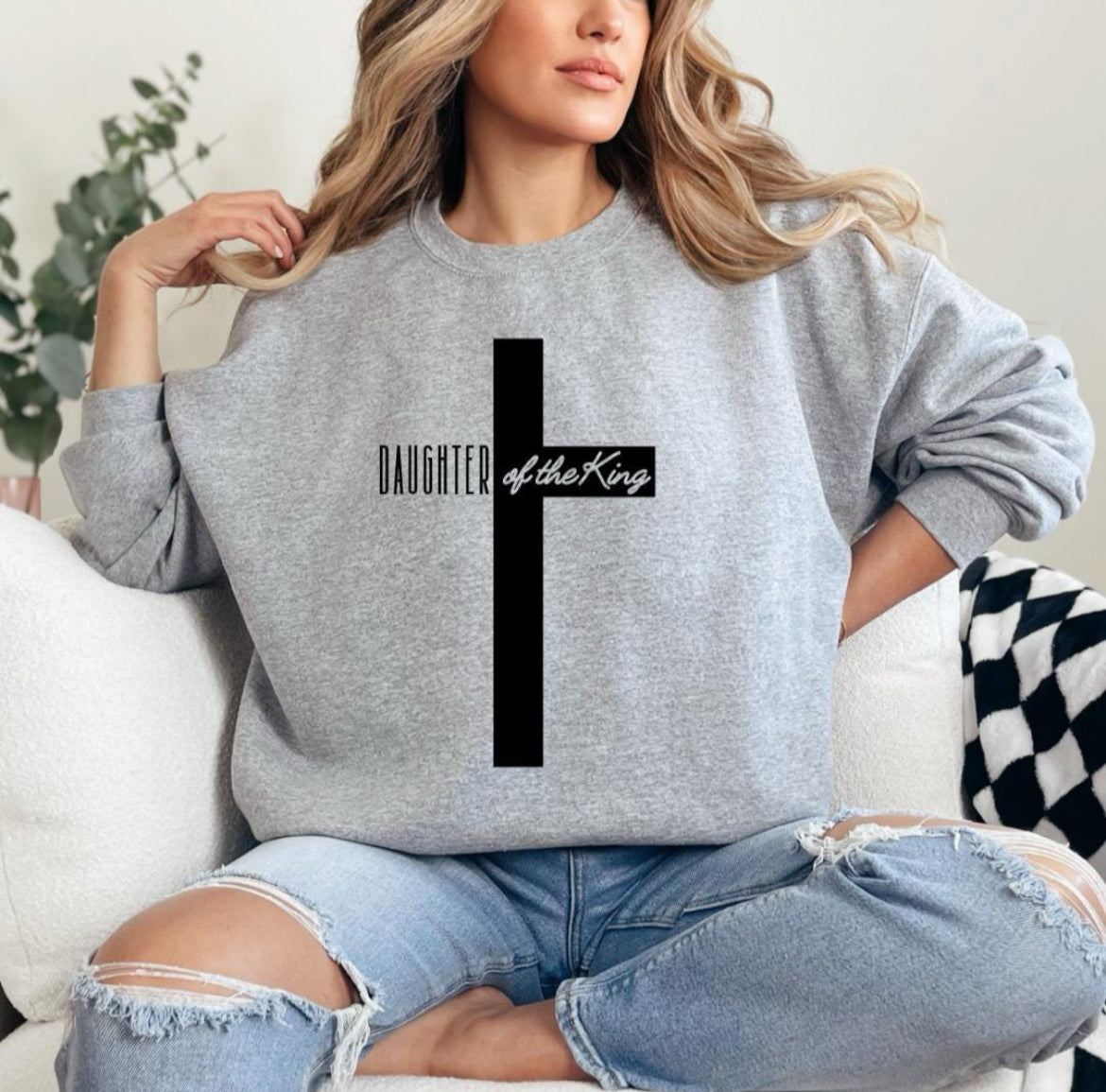 Spory gray crewneck sweatshirt with a large cross that says, "Daughter of the King," On the sleeve it says, "1 John 3:1."