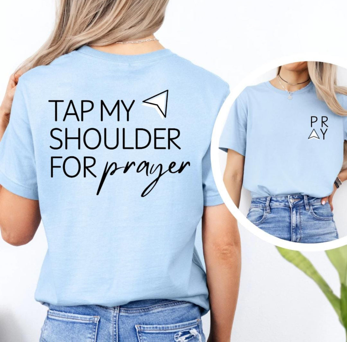 Baby blue Crewneck t-shirt that says, “tap my shoulder for prayer” with an aesthetic arrow pointing to the shoulder. On the front of the shirt it says, “PRAY” up in the left-hand corner of the shirt. 